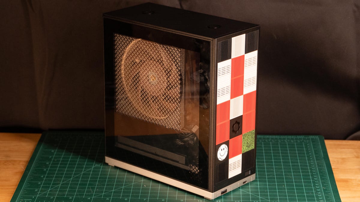 A compact 4.5-liter Framework Desktop showcasing its modular front tiles and clear side panel with a Noctua fan.