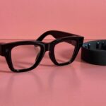 A close-up of a person wearing sleek Meta smart glasses while subtly gesturing with a neural-equipped smartwatch on their wrist.