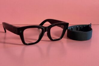 A close-up of a person wearing sleek Meta smart glasses while subtly gesturing with a neural-equipped smartwatch on their wrist.