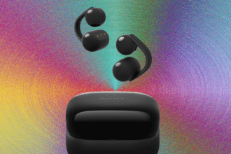 Detailed close-up of the Sony LinkBuds Clip open-ear headphones resting beside their compact, cookie-style charging case on a wooden desk.