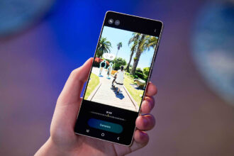 Close-up of a person using a Samsung Galaxy S Series smartphone to capture a vibrant night market scene with AI-enhanced lighting and clarity.