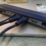 A person using a sleek holographic interface in a modern living room, emphasizing the shift from traditional file folders to AI-driven data retrieval.