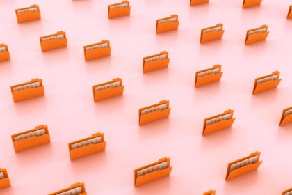 An external NVMe SSD drive sits beside a sleek laptop displaying a terminal window during a Linux distribution installation process.