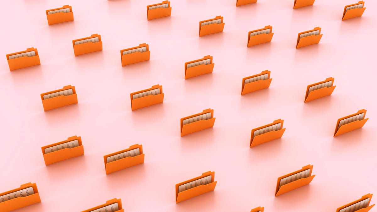 An external NVMe SSD drive sits beside a sleek laptop displaying a terminal window during a Linux distribution installation process.