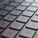 A person sitting in a dimly lit home office, frustratedly typing into a Linux terminal on a Microsoft Surface Pro tablet.