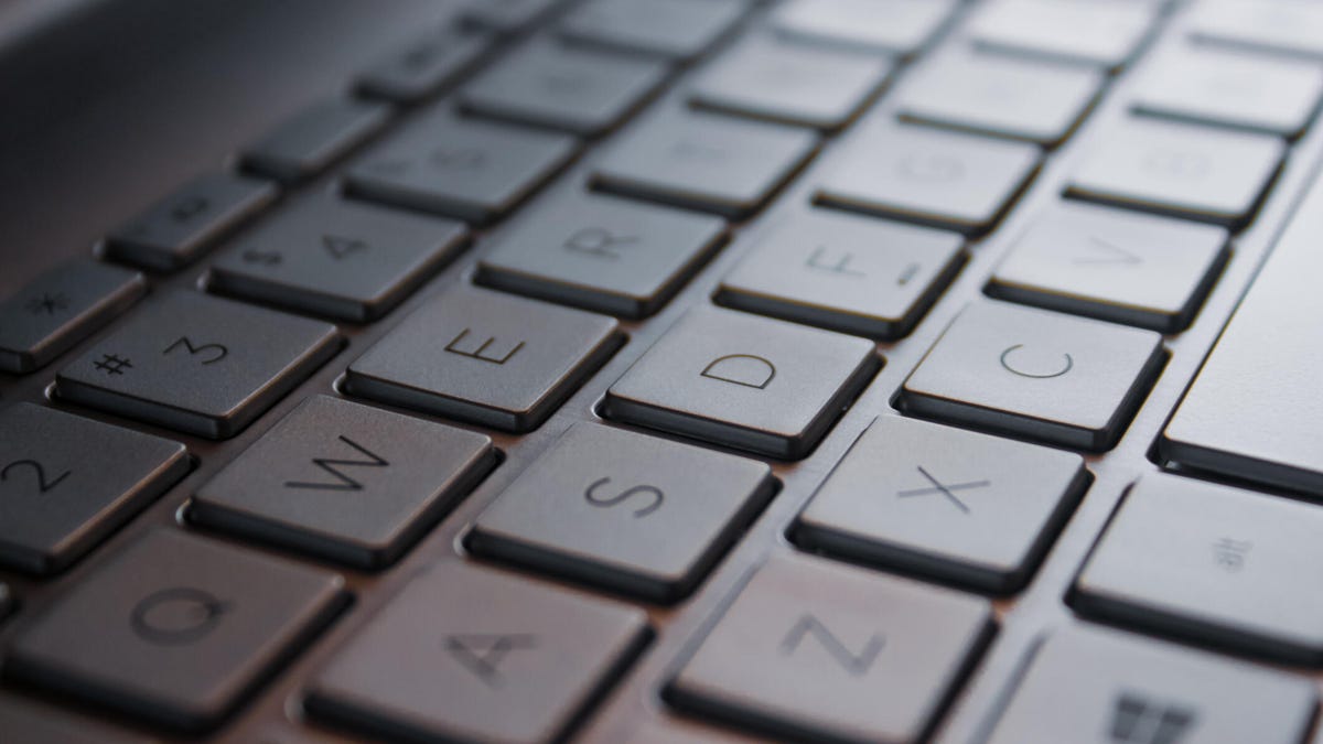 A person sitting in a dimly lit home office, frustratedly typing into a Linux terminal on a Microsoft Surface Pro tablet.