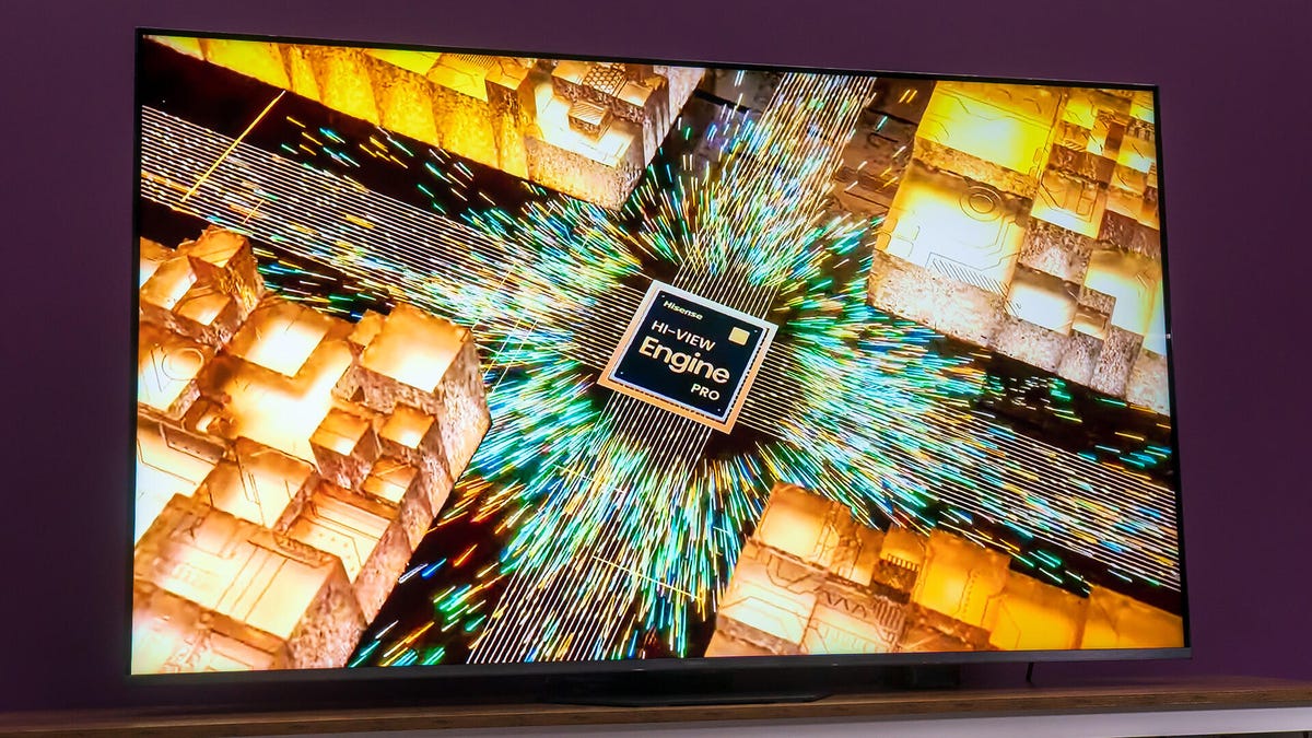 A 65-inch Hisense U8QG TV displaying vibrant 4K HDR cinematic content in a modern, sunlit living room setting.