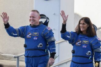 A sleek, buttonless glass tablet displaying a glowing conversational AI interface in a sunlit modern living room.