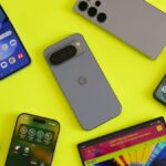 A close-up of the OnePlus 15 and iPhone 17 Pro Max side-by-side on a lab testing bench showing battery percentages.