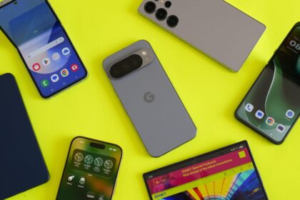 A close-up of the OnePlus 15 and iPhone 17 Pro Max side-by-side on a lab testing bench showing battery percentages.