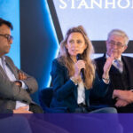 A sleek autonomous drone navigating a complex, dimly lit industrial warehouse, showcasing Stanhope AI's adaptive real-time navigation technology.