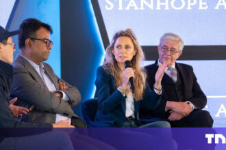 A sleek autonomous drone navigating a complex, dimly lit industrial warehouse, showcasing Stanhope AI's adaptive real-time navigation technology.