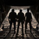 A high-end smartphone lying on a desk displaying the Call of Duty: Warzone Mobile loading screen next to a gaming headset.