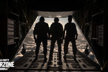 A high-end smartphone lying on a desk displaying the Call of Duty: Warzone Mobile loading screen next to a gaming headset.