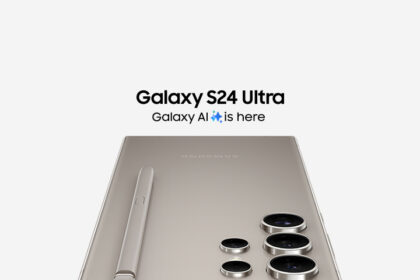 A person comparing the titanium frames and massive displays of a Samsung Galaxy S24 Ultra and S25 Ultra side-by-side on a wooden desk