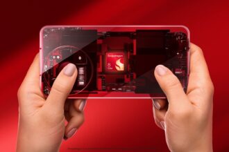 A sleek 2026 flagship smartphone disassembled on a wooden desk, highlighting the Snapdragon 8 Gen 5 chipset and its surrounding thermal cooling system.