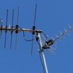 A sleek, modern Mohu Gateway Plus indoor antenna positioned discreetly on a minimalist bookshelf next to a high-end smart TV in a contemporary living room.