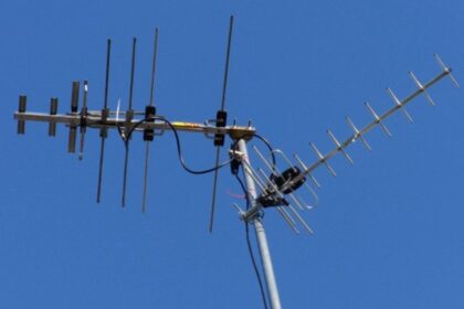 A sleek, modern Mohu Gateway Plus indoor antenna positioned discreetly on a minimalist bookshelf next to a high-end smart TV in a contemporary living room.