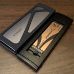 A tangled collection of various USB-C cables and high-end smartphones resting on a modern workstation, highlighting the complexity of universal charging standards.